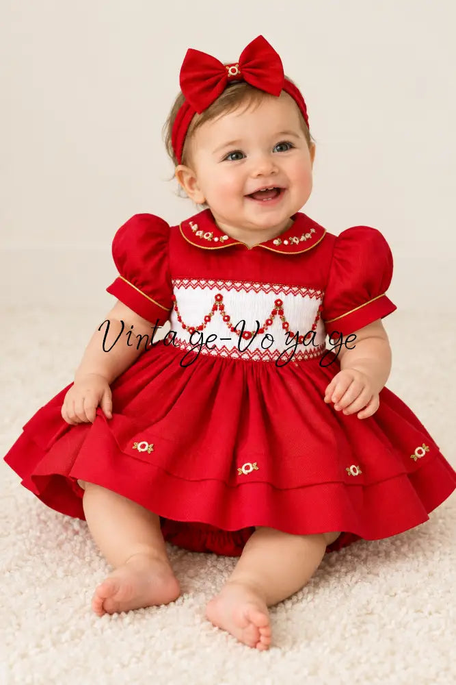 Baby model wearing the red smocked dress and matching bow